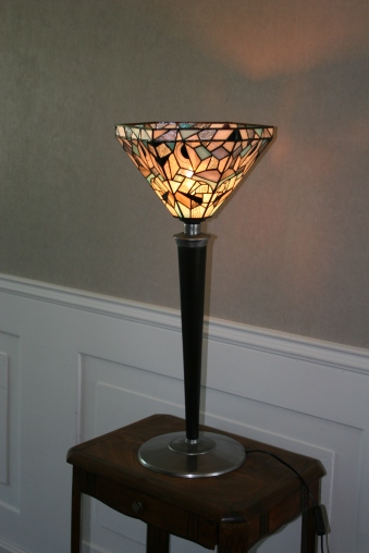 Elégance, originalité et design pour Tulipa 2, une très grande lampe ancienne à poser des années 30 pour le pied et le socle. Rénovée, son socle initialement revêtu d'une peinture marron foncé a été décapé pour laisser l'acier brut pour un aspect plus contemporain. Le pied en hêtre massif a également été décapé pour être teinté en noir Napoléon et vernis mat. Le luminaire type "tulipe" est constitué de 6 pans en verres motifs contemporains en vitrail Tiffany de couleur blanc, gris, turquoise, noir et transparent striés. Certains verres blancs ont été ornés de dessins naïfs peints à la grisaille et cuits à 650°. Toutes les pièces de verre ont été soigneusement recherchées et sélectionnées pour leur aspect brut et "torturé", ceci pour renforcer le contraste entre l'aspect contemporain de cette lampe et le côté ancien du vitrail Tiffany. Dans le même esprit, les soudures et finitions ont été patinées. Très grande : Hauteur 74 cm, diamètre 33 cm.