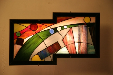 Nineleven : applique murale vitrail Tiffany, verres opalescents. Montée sur structure électrifiée en acier blanc. Hauteur 26 cm, largeur 56 cm.