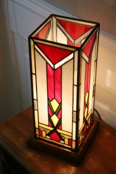 Lampe Art Déco en vitrail Tiffany forme colonne. Verres opalescent blanc, rouge, vert et jaune lumineux et profond. Socle en noyer massif doré.