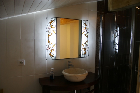 Miroir de salle de bain entouré de 2 vitraux Tiffany et plomb traditionnel. Verres translucides structurés de gouttes et cabochons de miroirs